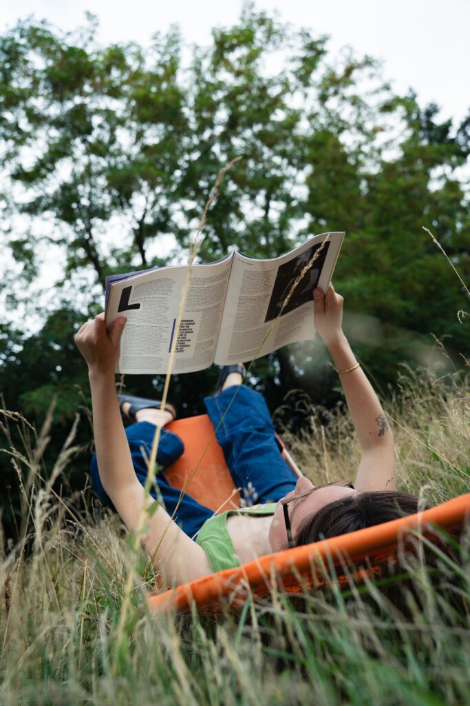 Salomé lit un magazine allongée sur sa chaise longue dans le jardin.